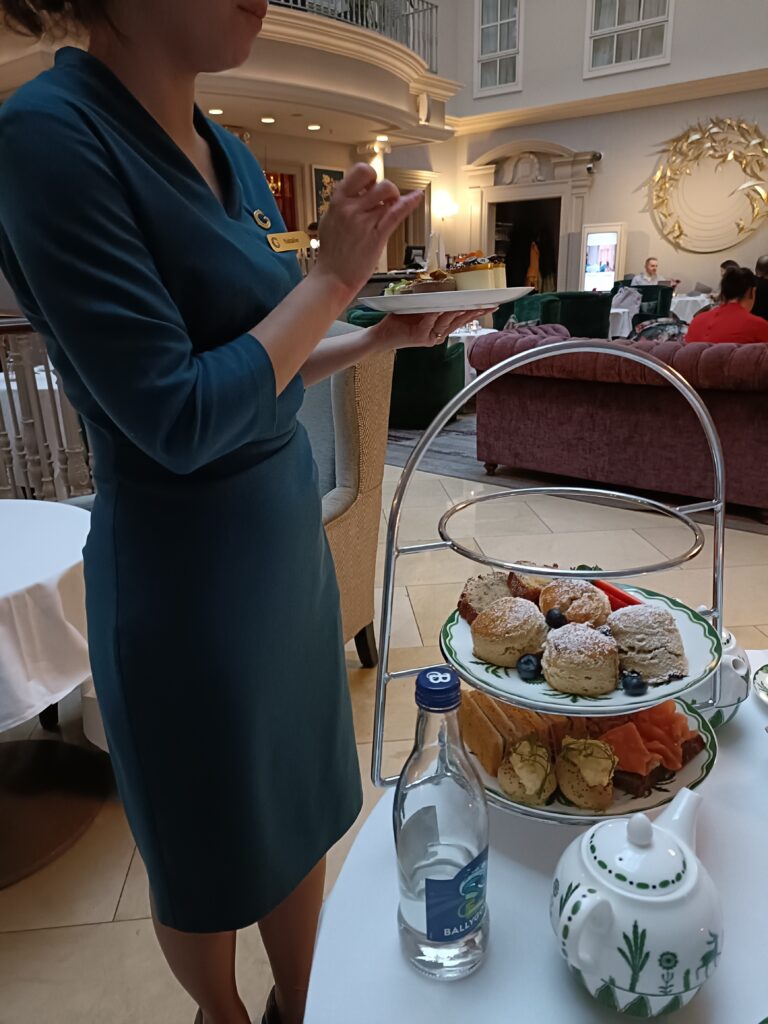 afternoon tea at the college green hotel served by a member of staff